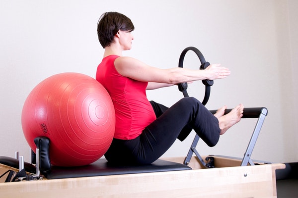 woman-in-red-top-leaning-on-red-stability-ball-1103254