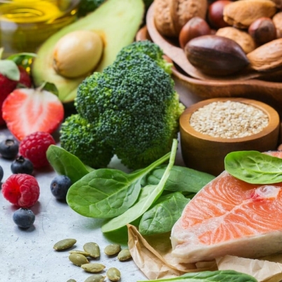 group of healthy foods including salmon, broccoli, spinach, pumpkin seeds, berries, and avocado