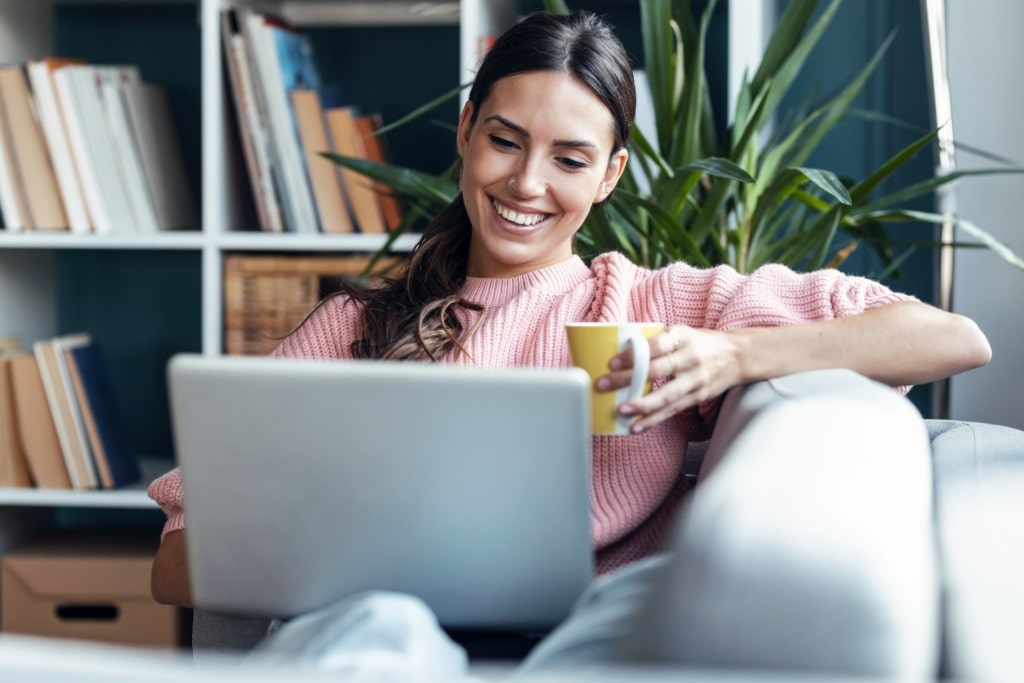 woman online learning on her laptop with a healthy drink