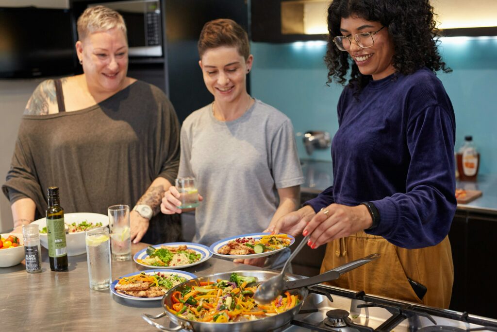 People cooking and plating healthy food in kitchen